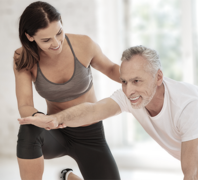 Man in a pose while an instructor assists