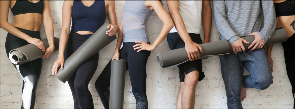 Group of people holding pilates mats
